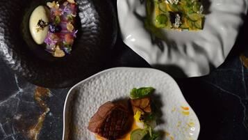A marble table with three dishes of food.