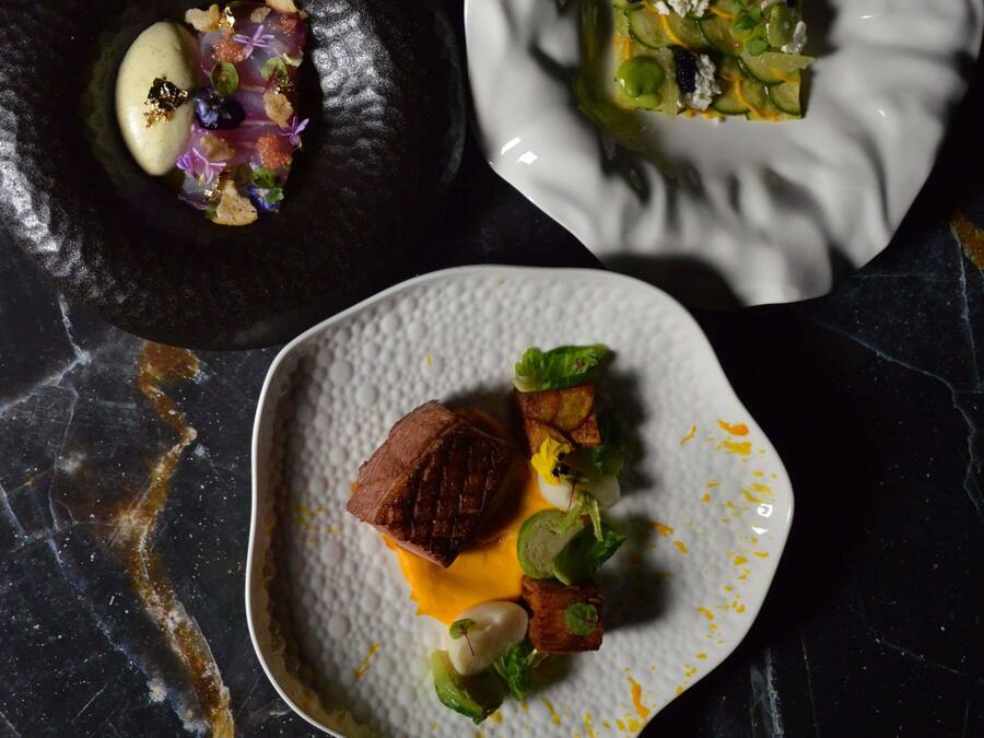 A marble table with three dishes of food.
