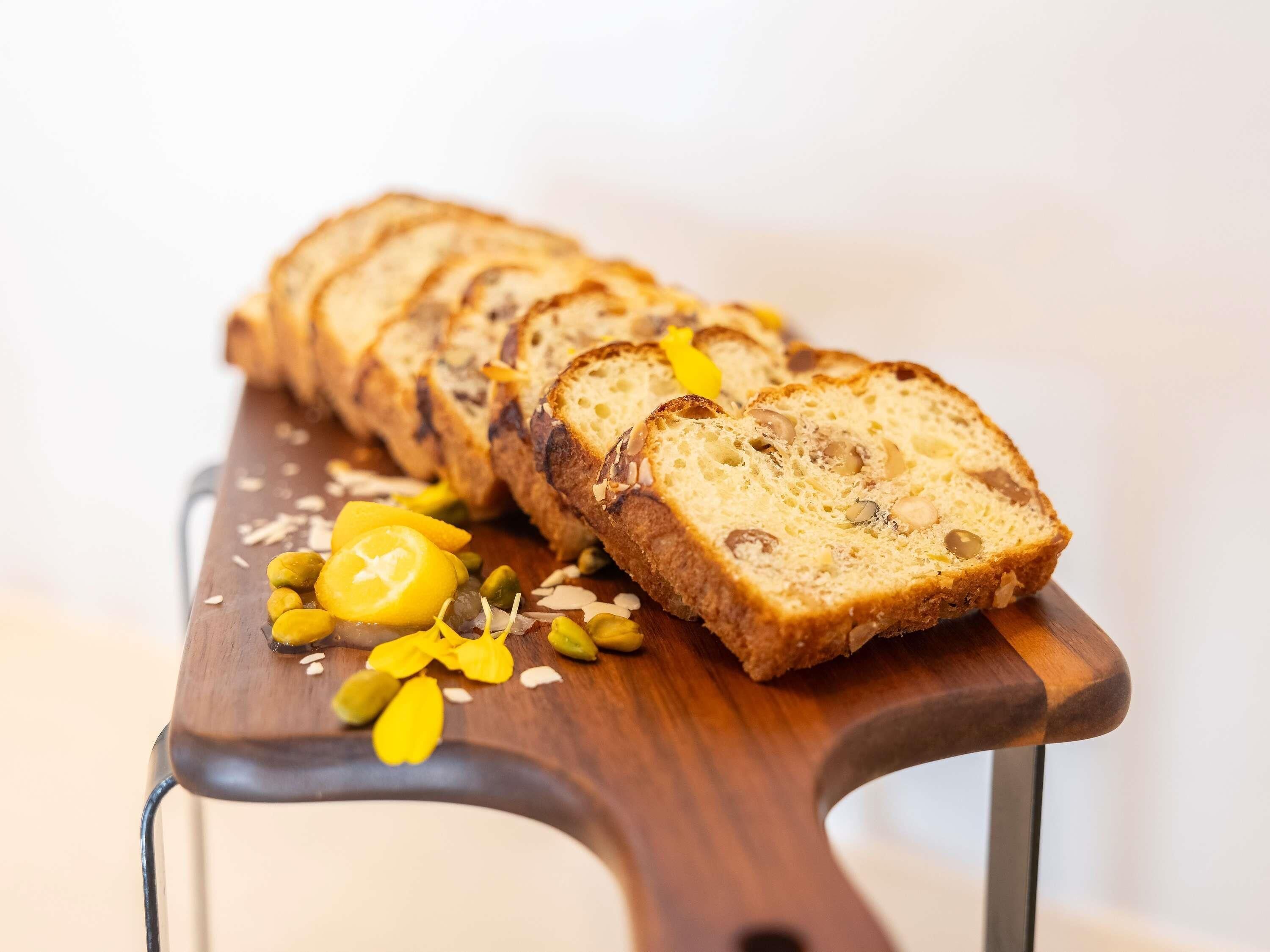 Rebanadas de pan con nueces y fruta seca sobre una tabla de madera.
