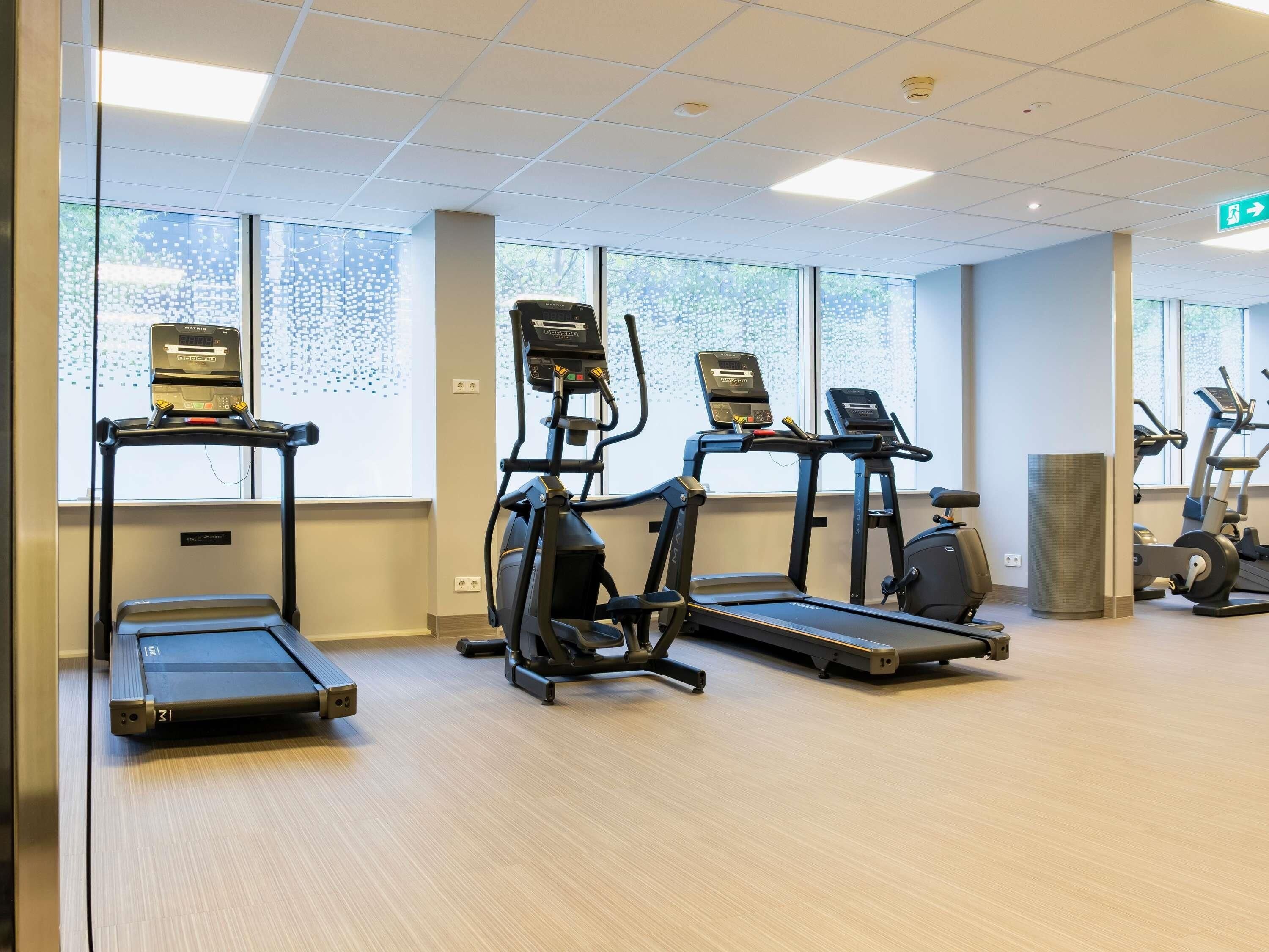 A gym with treadmills, elliptical machines, and a stationary bike.