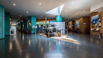 A spacious lobby with a vintage truck display, teal pillars, and artwork on the walls.
