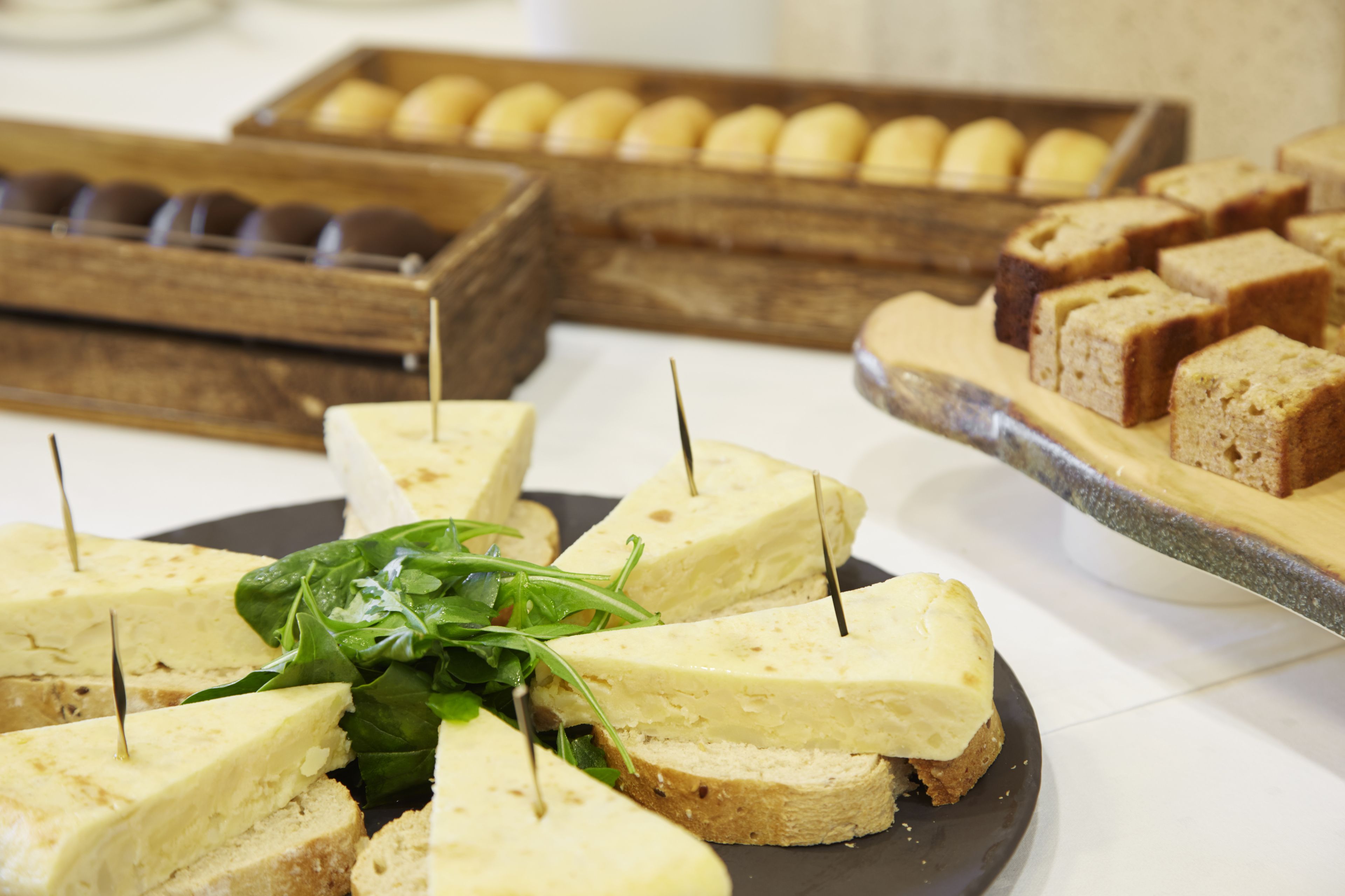 Une variété de sandwichs et de viennoiseries sont disposés sur une table.