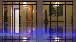 A modern interior with glass doors, a tiled floor, and a large abstract painting. - Novotel Paris Roissy CDG Convention (Roissy-en-France)