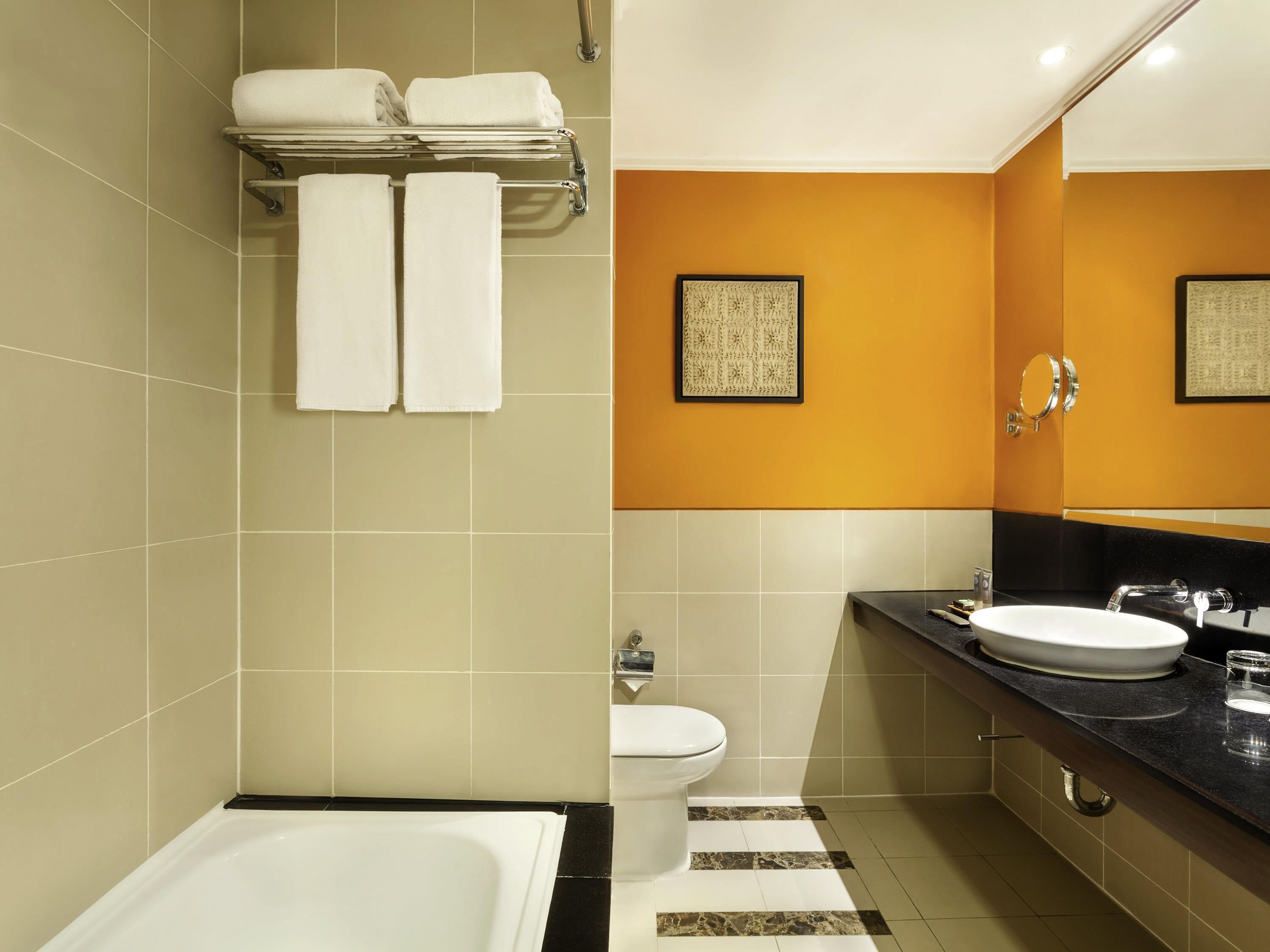 Une salle de bain moderne équipée d’une baignoire, de toilettes et d’un lavabo.