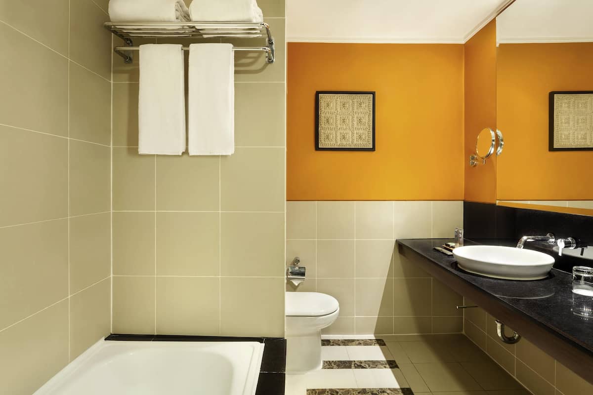 A modern bathroom with a bathtub, toilet, and sink.