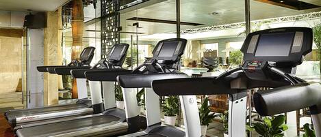 A fitness area with treadmills, a weight bench, and a rowing machine.
