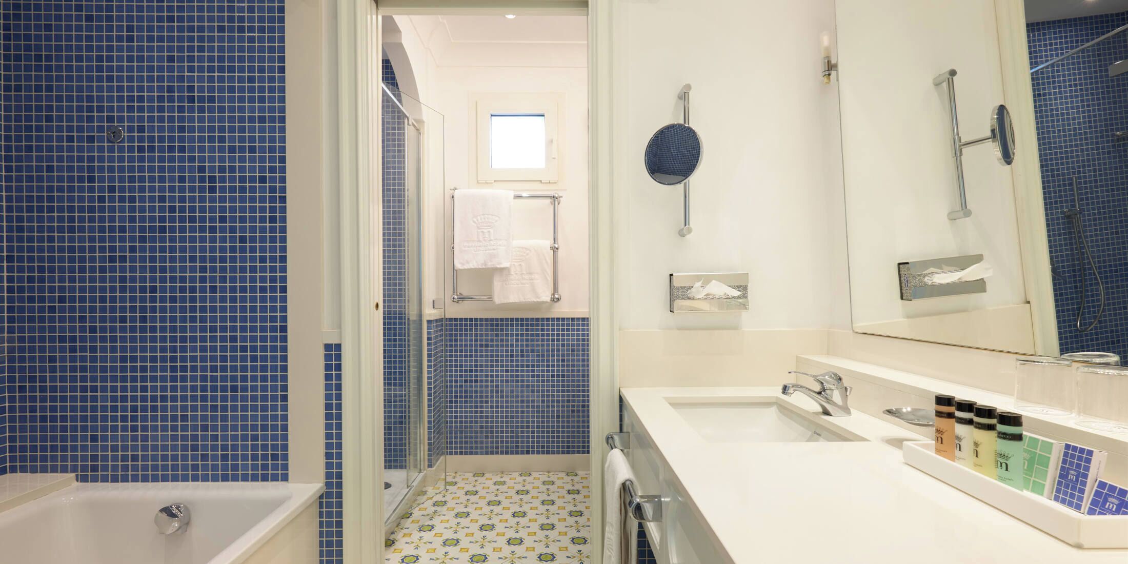 A bathroom with a bathtub, a sink, a mirror, and a shower area.