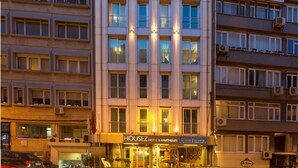 A multi-story hotel with a modern facade, large windows, and a ground-level restaurant. - Housez Suites and Apartments - Special Class (Istanbul)