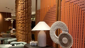 A modern interior with a curved reception desk, a wooden column, and a decorative wall panel. - Housez Suites and Apartments - Special Class (Istanbul)