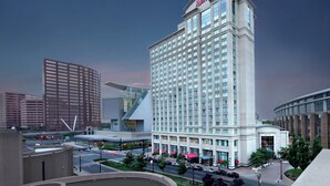 A Marriott hotel with a modern design, featuring a prominent corner location, large windows, and a well-maintained outdoor area with trees and a parking lot. - Marriott Hartford Downtown (Hartford)