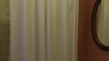 A bathroom with a shower curtain, a sink, and a mirror.