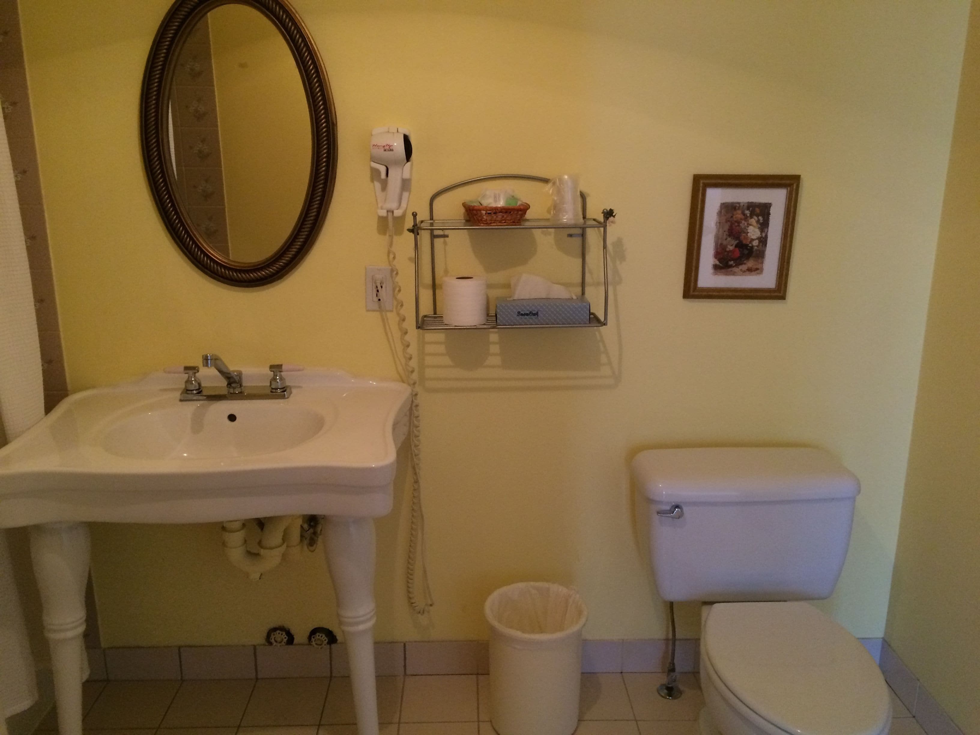 Un baño con lavamanos, inodoro y espejo.