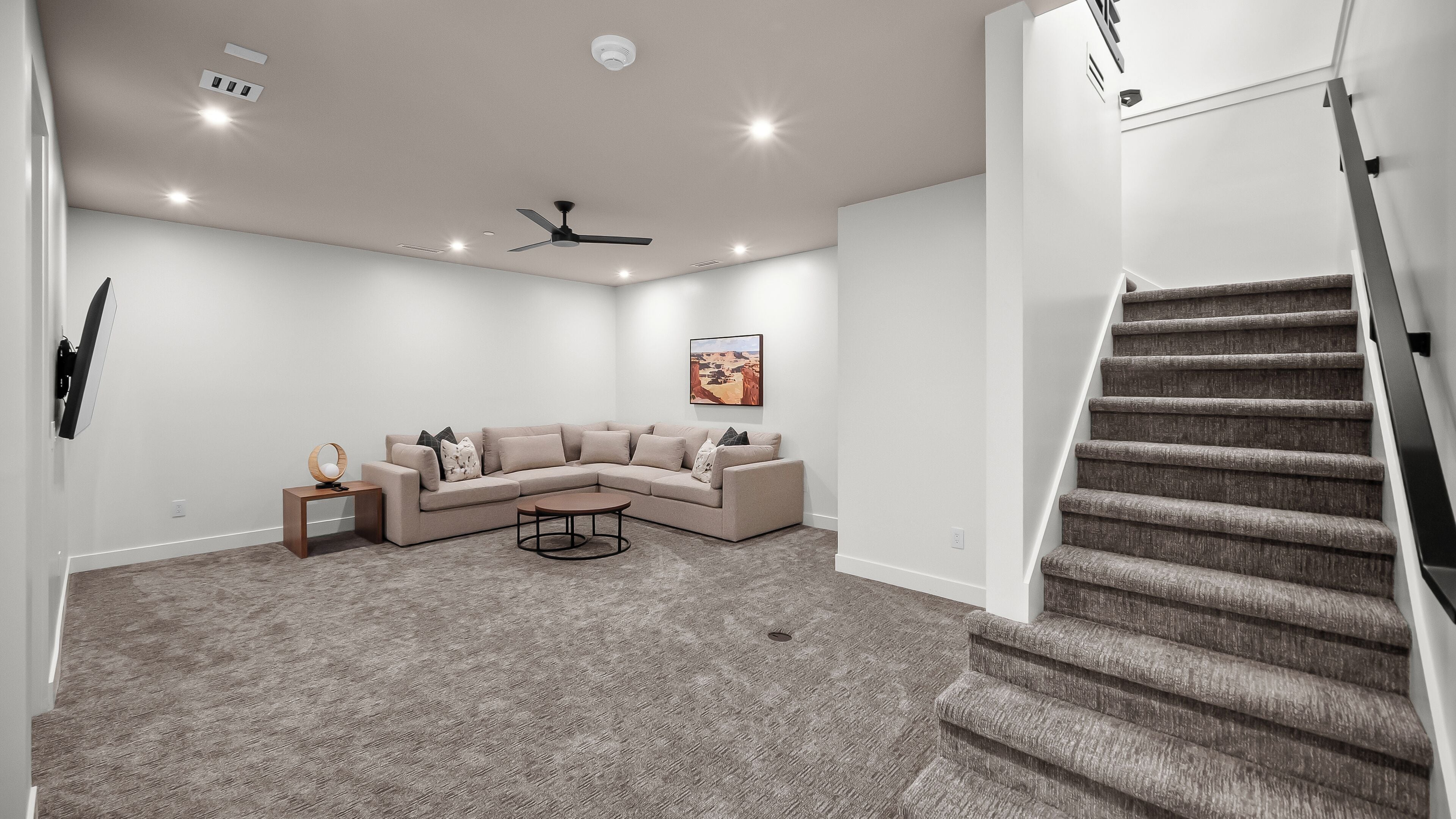 Una sala de estar moderna con un sofá modular, una mesa de centro y una escalera.