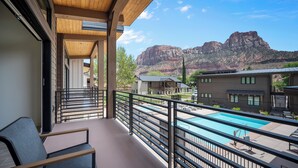 A balcony with a view of a mountain and a swimming pool. - Montclair at Zion (Springdale)