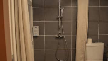 A bathroom with a shower, toilet, and a towel rack.