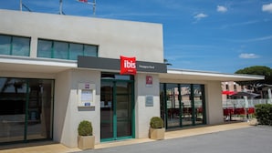 The exterior of the ibis hotel with a clear sky, large windows, and a sign indicating the location as Perpignan Nord. - Ibis Perpignan Nord Rivesaltes (Rivesaltes)