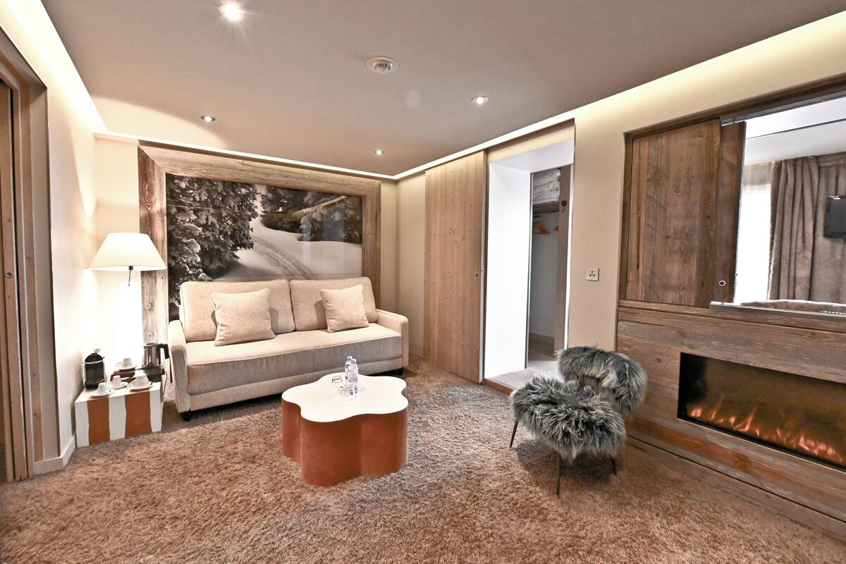 Een moderne woonkamer met een bank, salontafel en een open haard.