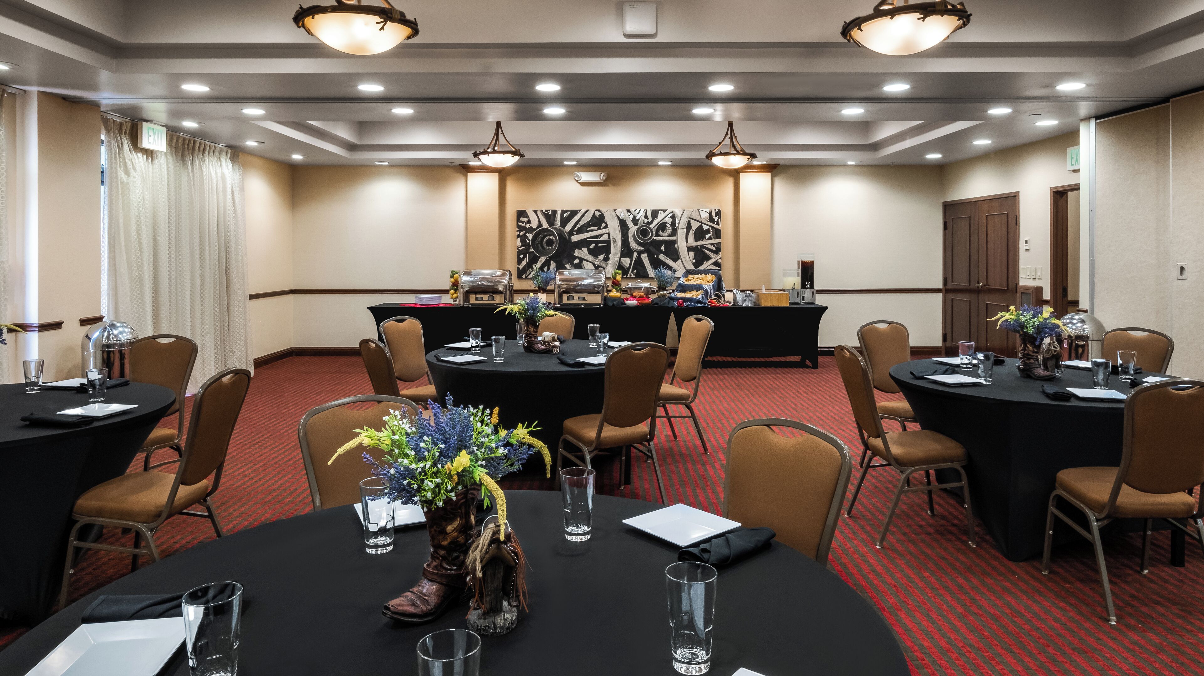 Un salón de conferencias con mesas redondas, sillas y una zona de bufé.