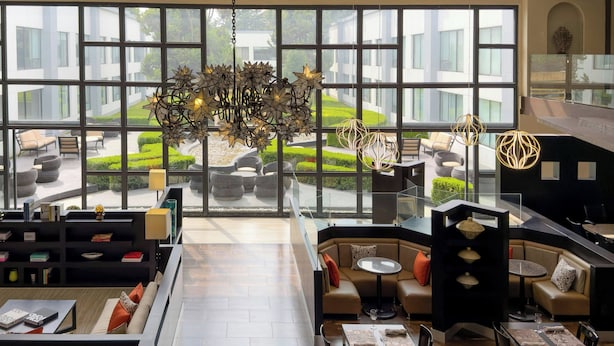 A modern interior with a large window view, a unique chandelier, and a mix of seating areas.