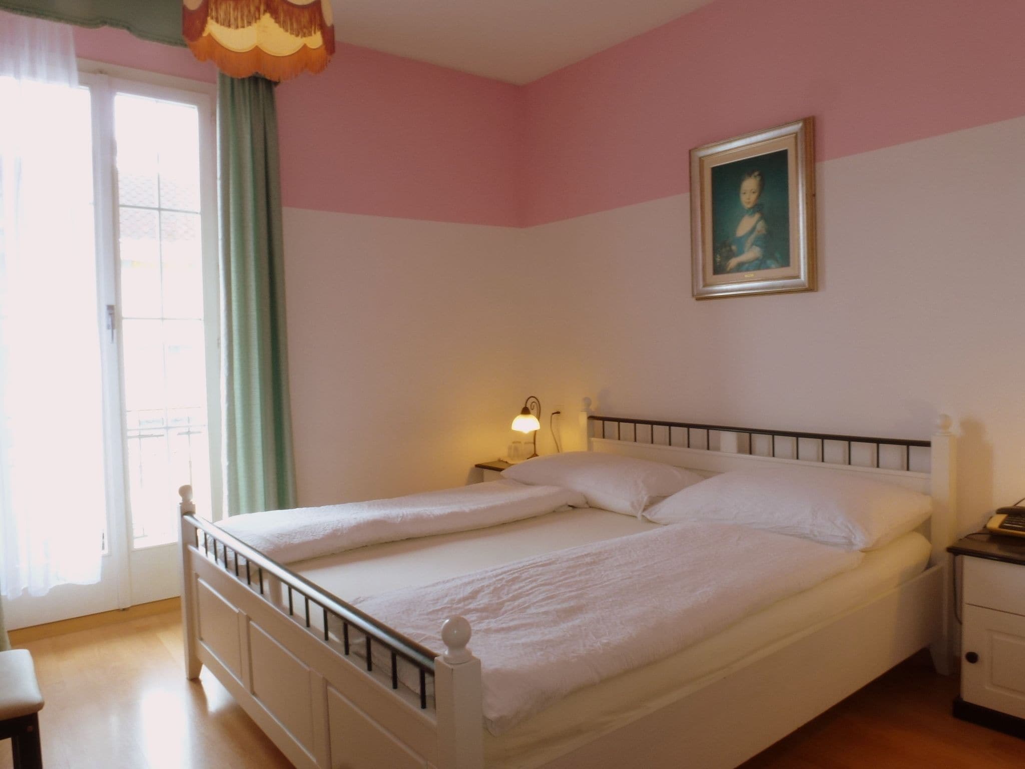 Une chambre à coucher avec un lit, une table de chevet, une lampe et un tableau au mur.