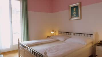 Une chambre à coucher avec un lit, une table de chevet, une lampe et un tableau au mur.