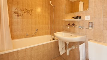 Un baño con bañera, lavabo e inodoro.