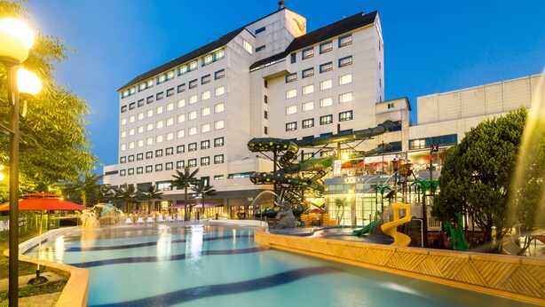 A hotel with a swimming pool, outdoor seating, and a water slide. - Hotel Miranda (Icheon)
