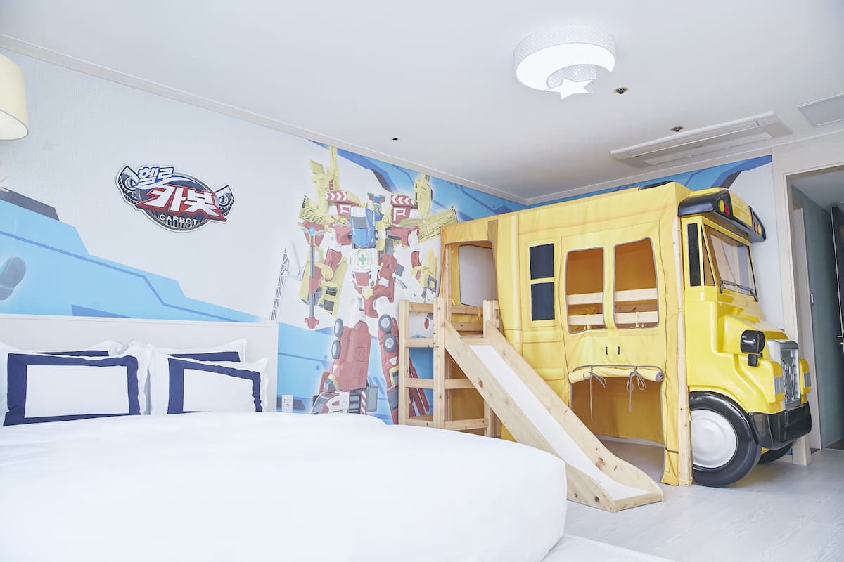 A child's bedroom with a bed, a play area, and a wall mural.