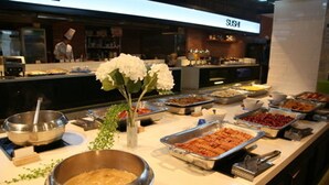 A buffet area with various food items and a 'SUSHI' sign in the background. - Hotel Miranda (Icheon)