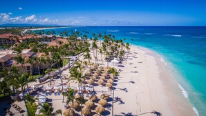 A beach resort with a sandy shoreline, palm trees, and a clear blue ocean. - Majestic Colonial Punta Cana - All Inclusive (Punta Cana)