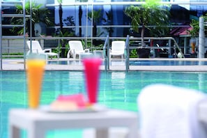 A swimming pool with lounge chairs and a clear view of the surrounding greenery and building. - Jinling Purple Mountain Hotel Shanghai (Shanghai)