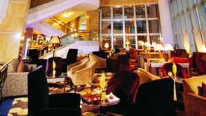 A spacious lobby with a high ceiling, a central staircase, and a large window providing natural light. - Jinling Purple Mountain Hotel Shanghai (Shanghai)