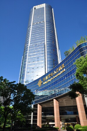 A tall, modern building with a curved facade and large glass windows. - Jinling Purple Mountain Hotel Shanghai (Shanghai)