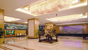 A spacious lobby with a large chandelier, a reception desk, and a decorative fountain. - Jinling Purple Mountain Hotel Shanghai (Shanghai)
