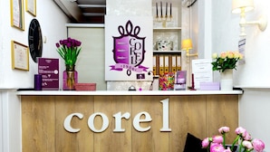 A reception desk with a wooden backdrop and the name 'corel' prominently displayed. - Hotel Corel (The Hague)