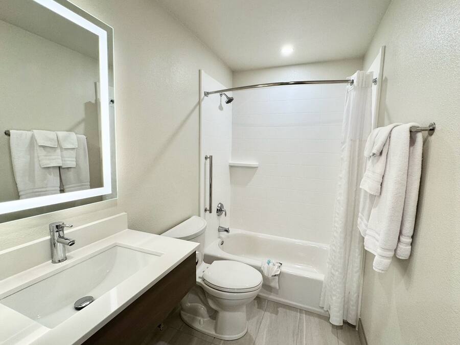 Un baño con lavamanos, inodoro y bañera.