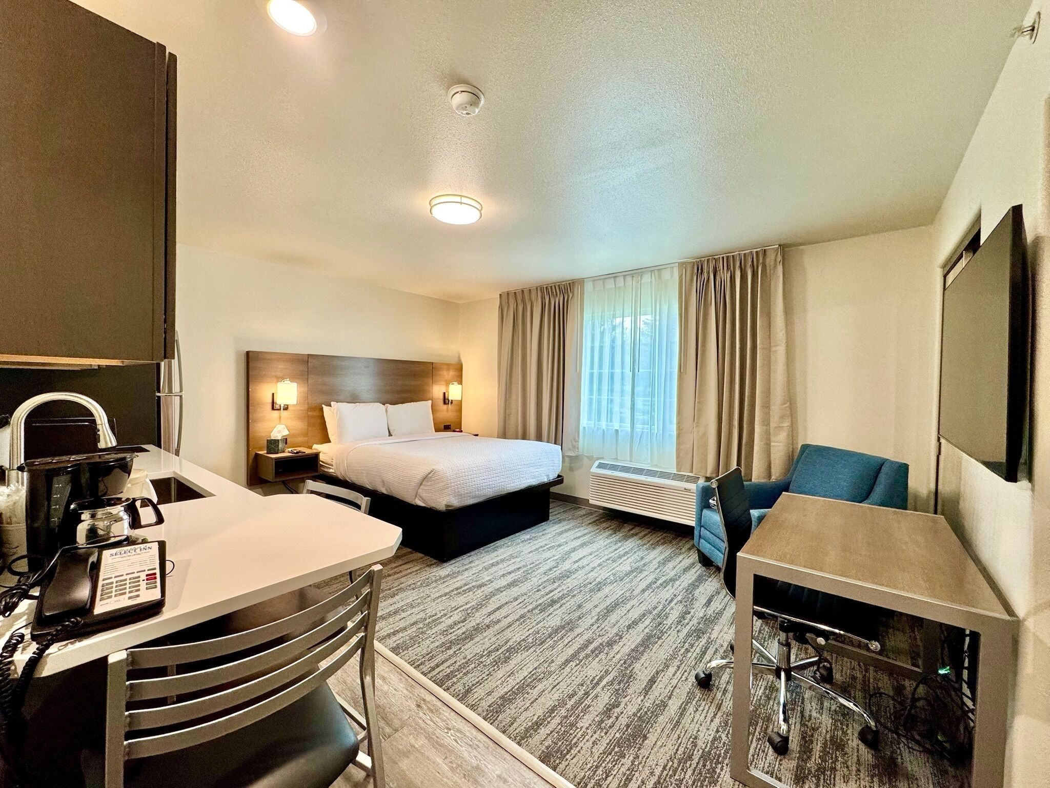 Une chambre d’hôtel équipée d’un lit, d’un bureau, d’une chaise et d’un téléviseur.