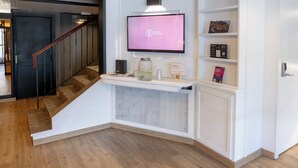 Un interior moderno con una escalera, un televisor de pantalla plana y estanterías empotradas.