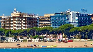 A coastal hotel with multiple floors, balconies, and a beachside location. - Blaumar (Blanes)