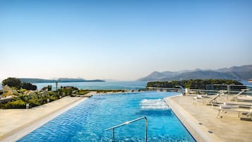 Una piscina techada, una piscina al aire libre de temporada, sombrillas