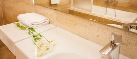 Une salle de bain avec un lavabo blanc, un miroir et une douche.