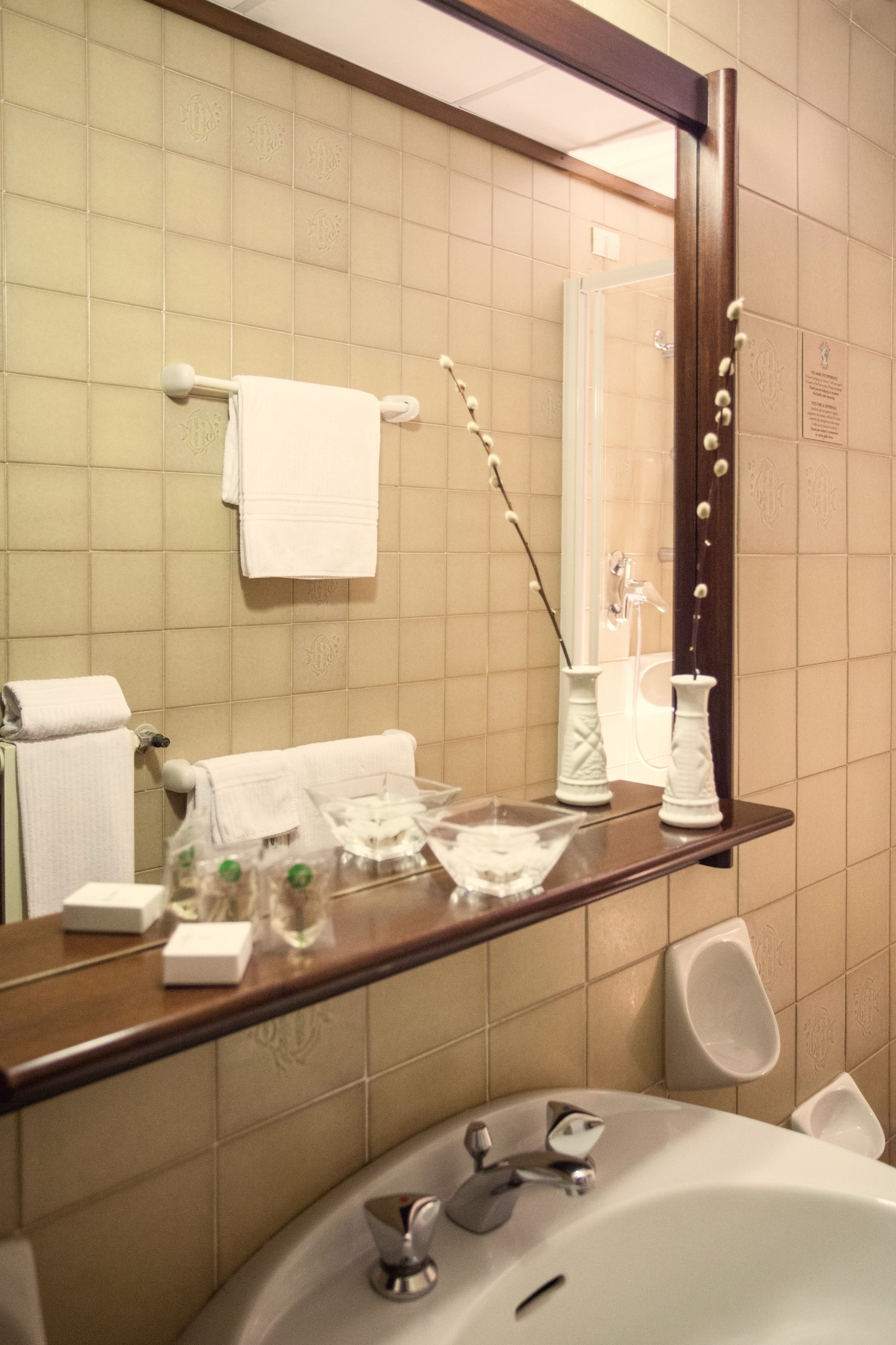 A bathroom with a sink, mirror, and toiletries.