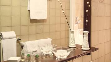 A bathroom with a sink, mirror, and toiletries.
