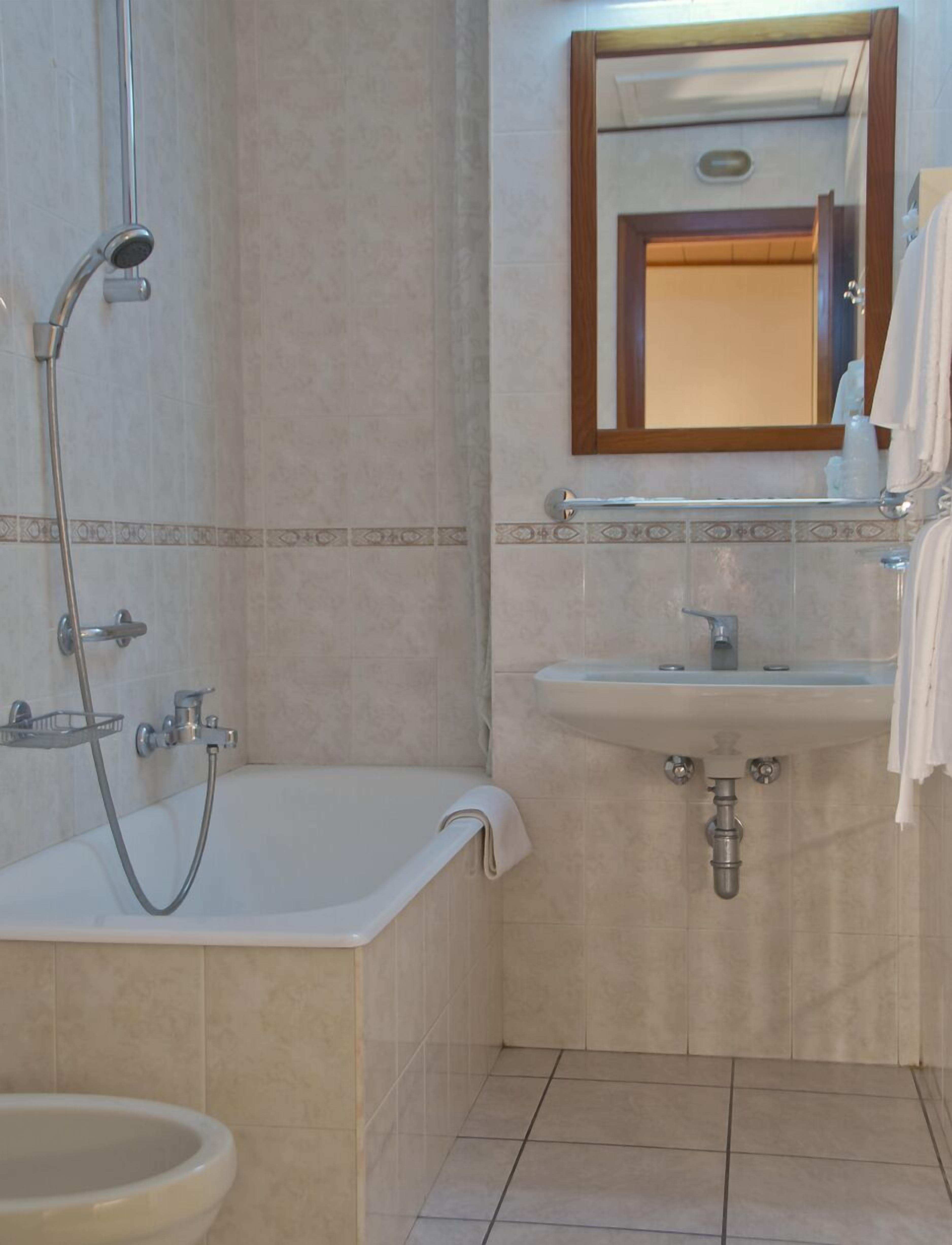 Un baño con bañera, lavamanos y ducha.