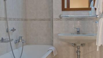 Un baño con bañera, lavamanos y ducha.