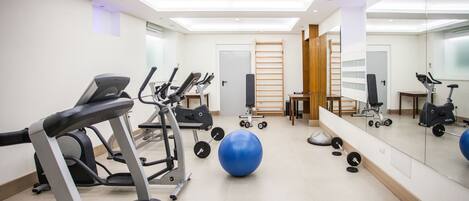 A gym with treadmills, exercise balls, and weight equipment.