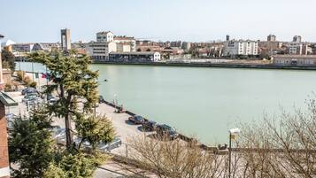 Vista sull'acqua con edifici, un'area parcheggio e cielo sereno.