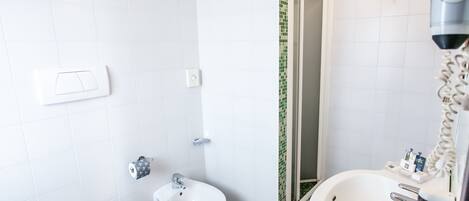 A bathroom with a toilet, bidet, and bathtub.