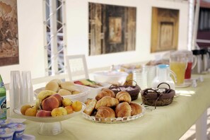 A buffet table with various food items, including fruits, pastries, and beverages. - Hotel Villa dei Misteri (Pompei)