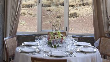 Mesa de comedor preparada para seis personas, con vista a la montaña a través de un amplio ventanal.